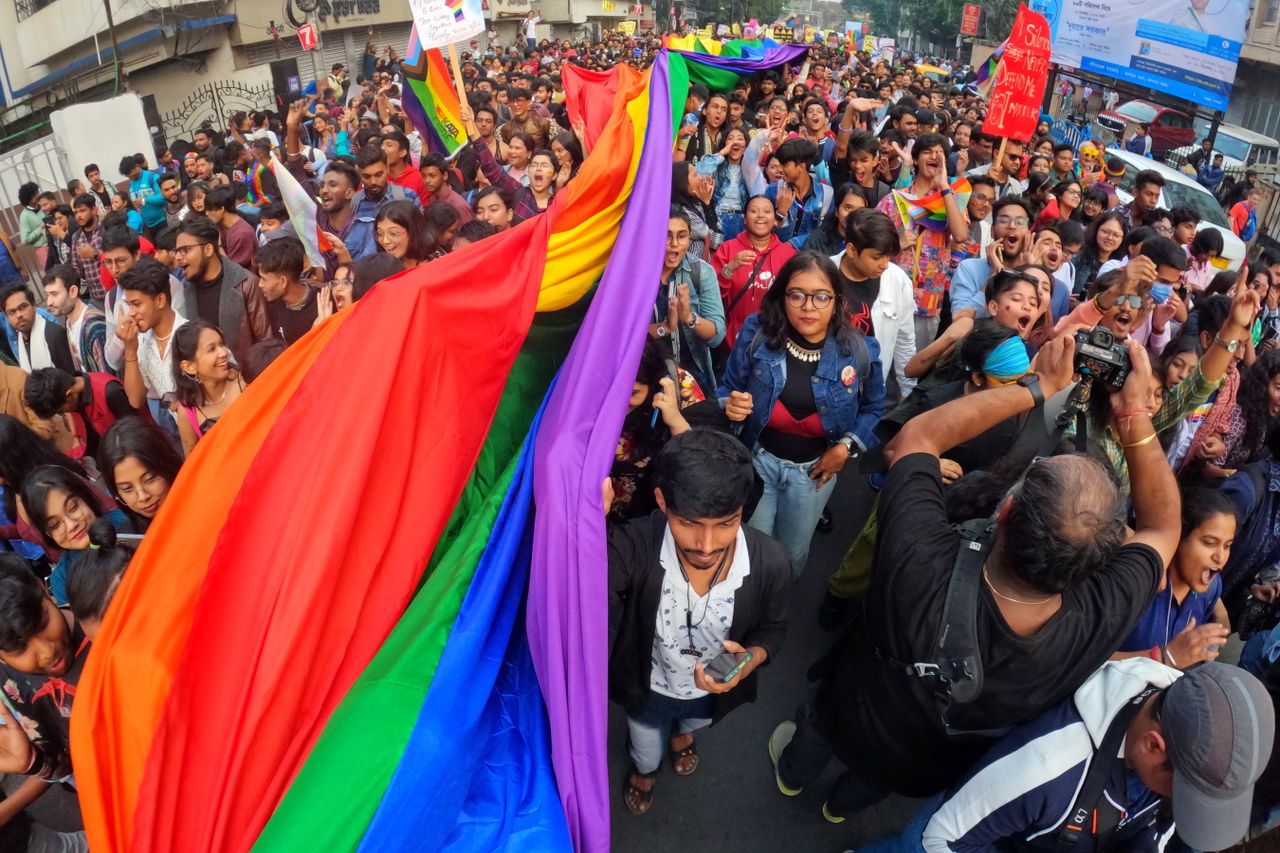 Aktuelles Vibrant pride parade in Kolkata, India, showcases unity and diversity with a large LGBTQ+ crowd and rainbow flag.